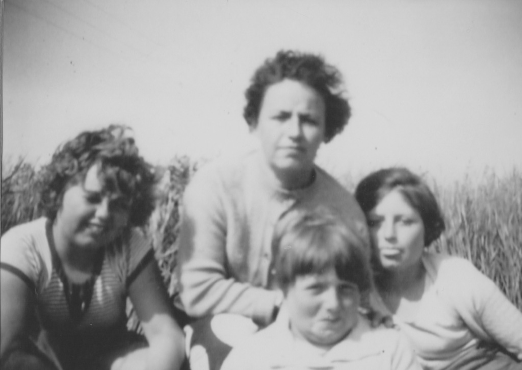 Black and white photo of my Nan, sat with her three daughters in front of her, all sat in front of the bullrushes on a holiday. The girls will be in their early teens.